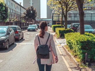 Young Solo Traveler Woman Walks Down a Street