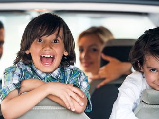Two cheerful kids on a car backseat