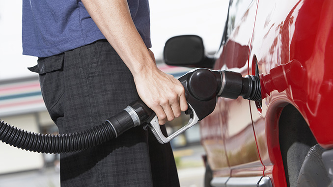 man filling car with gas at gas station