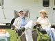 Senior couple sit outside rv home
