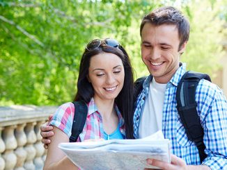 smiling couple travelers holding a map